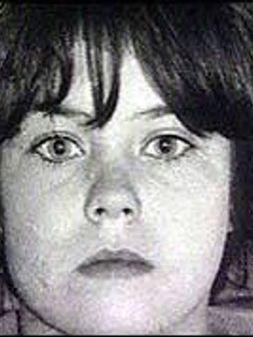 Black and white close-up of a young girl with a neutral expression.