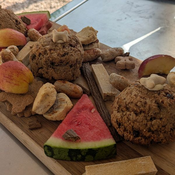 Wooden board with assorted snacks and fruits.