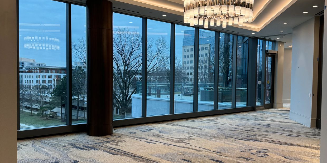 A spacious room with large windows and city views.