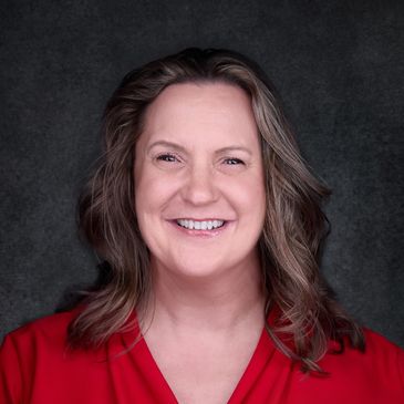 Picture of owner of the agency with brown hair and red shirt