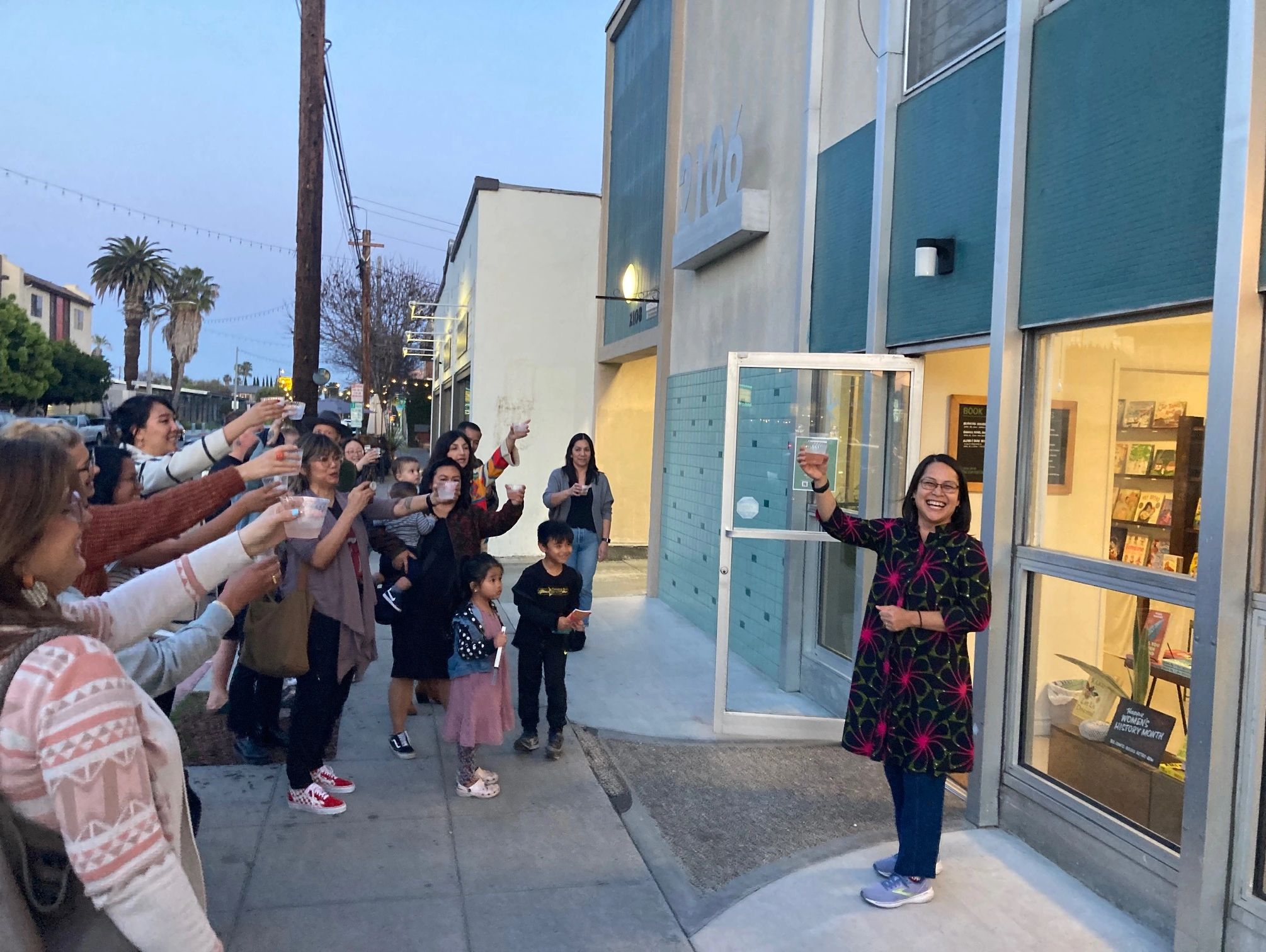 Bel Canto Books owner Jhoanna toasting well-wishers outside her bookstore in Long Beach CA