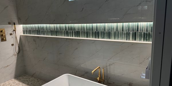 Modern bathroom with a freestanding tub and gold fixtures.