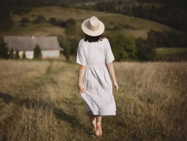 barefoot woman in golden field — symbol of intuitive return, belonging, and soul remembrance