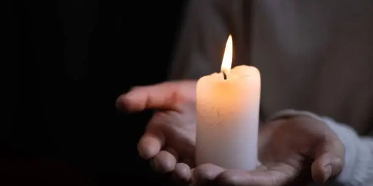 hands holding candle — symbol of soul presence, sacred holding, and transformational space