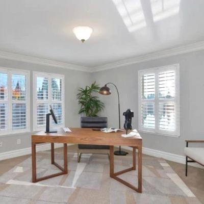 Modern minimalist home office with wooden desk and large windows.