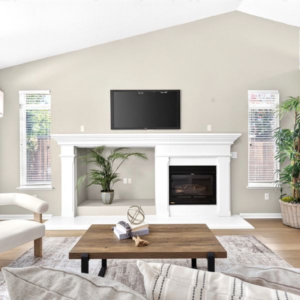 Modern living room with white fireplace and mounted TV.
