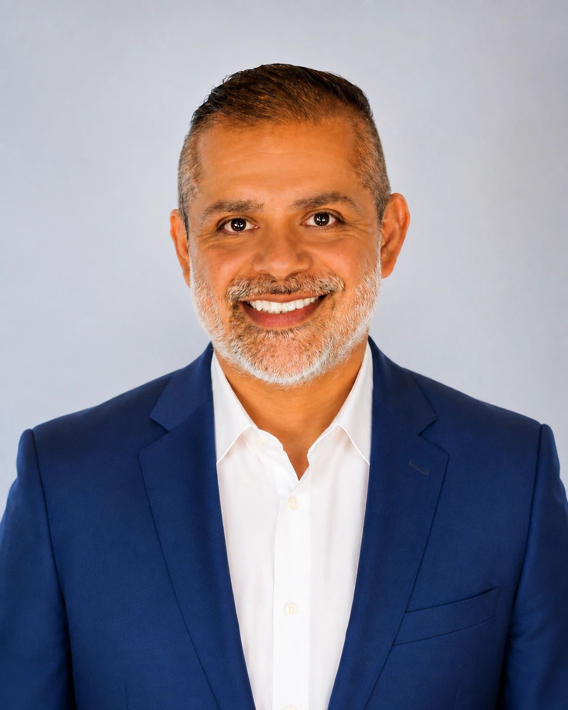 Smiling man in a blue suit jacket and white shirt.