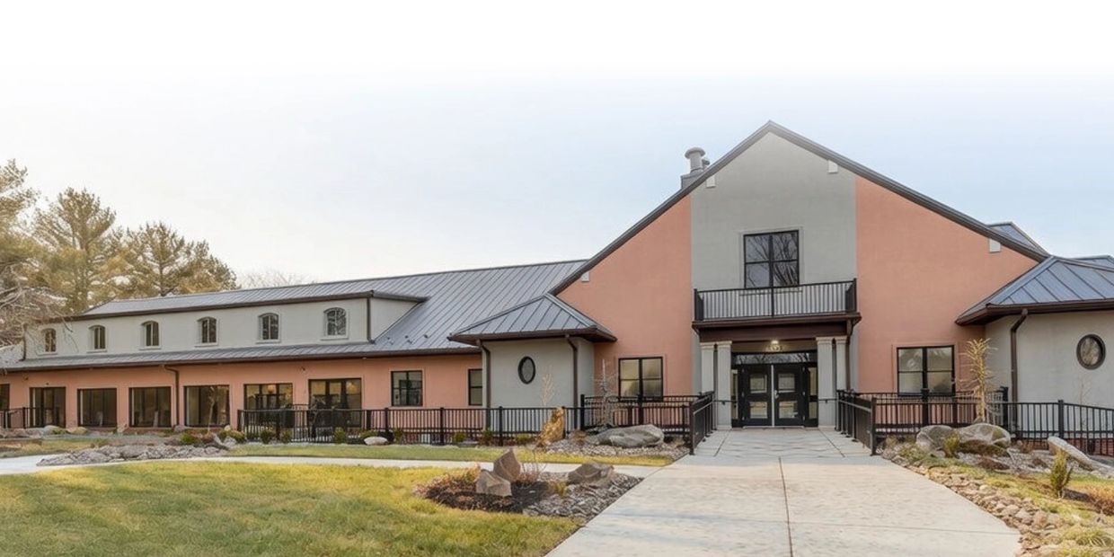 Modern building with peach and gray exterior and metal roof.