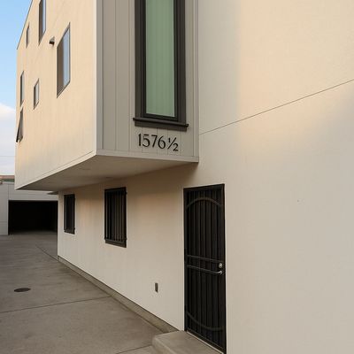 Modern building exterior with black-framed windows and a unique address number.