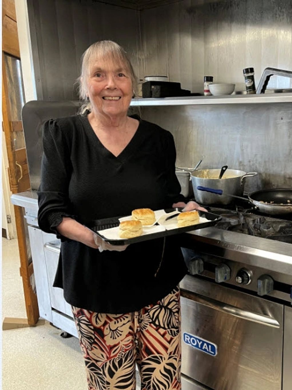 Image of helper serving biscuits and gravy