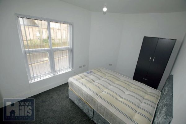 Simple bedroom with bed and wardrobe.