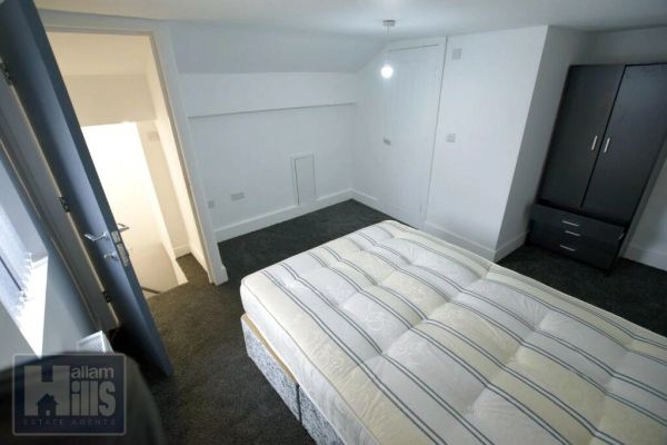 Minimalist bedroom with bed and wardrobe.