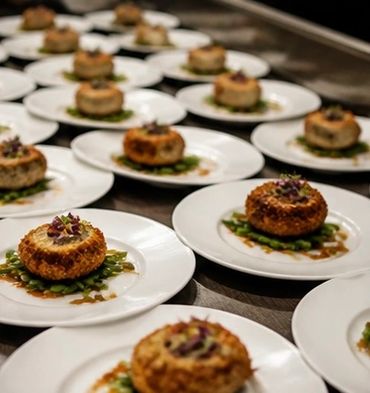 Plates with gourmet appetizers arranged on a table.