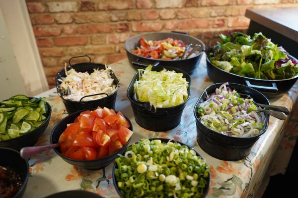 Various fresh salad ingredients in bowls on a table.