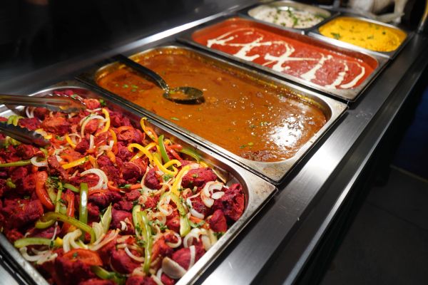 Buffet with various Indian dishes including tandoori chicken and curries.