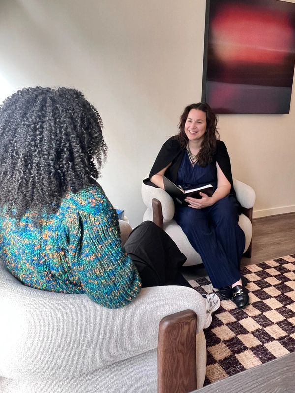 Two women engaged in a friendly conversation in a cozy room.