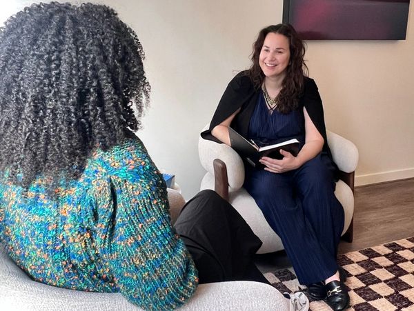 Two women engaged in a friendly conversation in a cozy room.