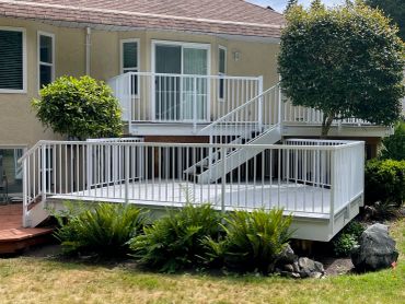 White deck with stairs and railing attached to a house.