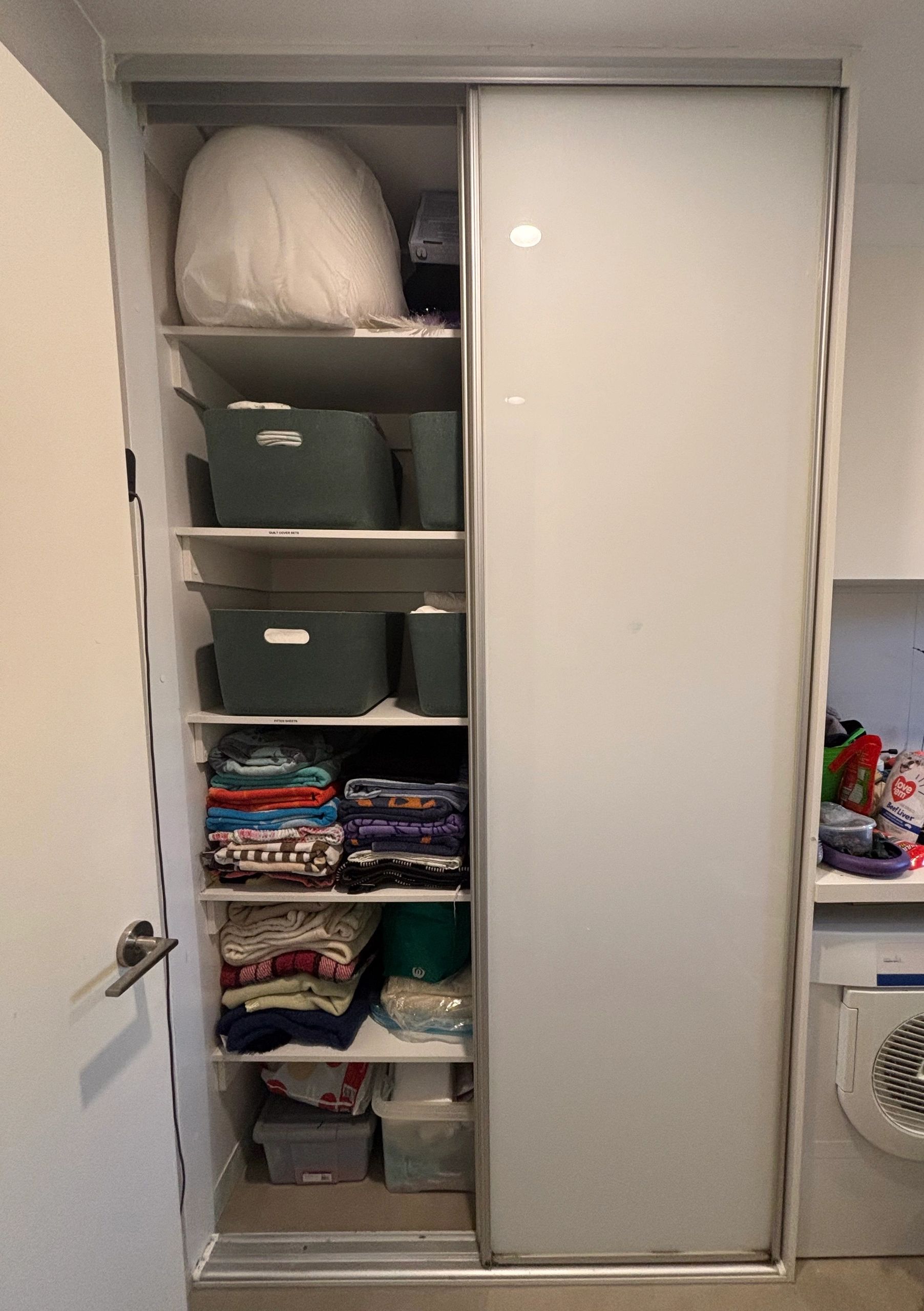 Organized closet with folded clothes and storage bins.