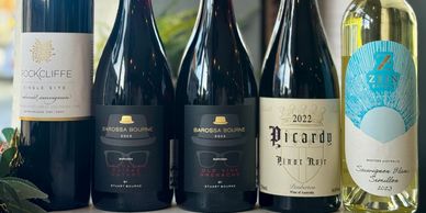 A lineup of five assorted wine bottles with elegant labels.