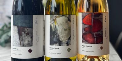 Three bottles of wine with artistic labels from St. Pentagh vineyard.