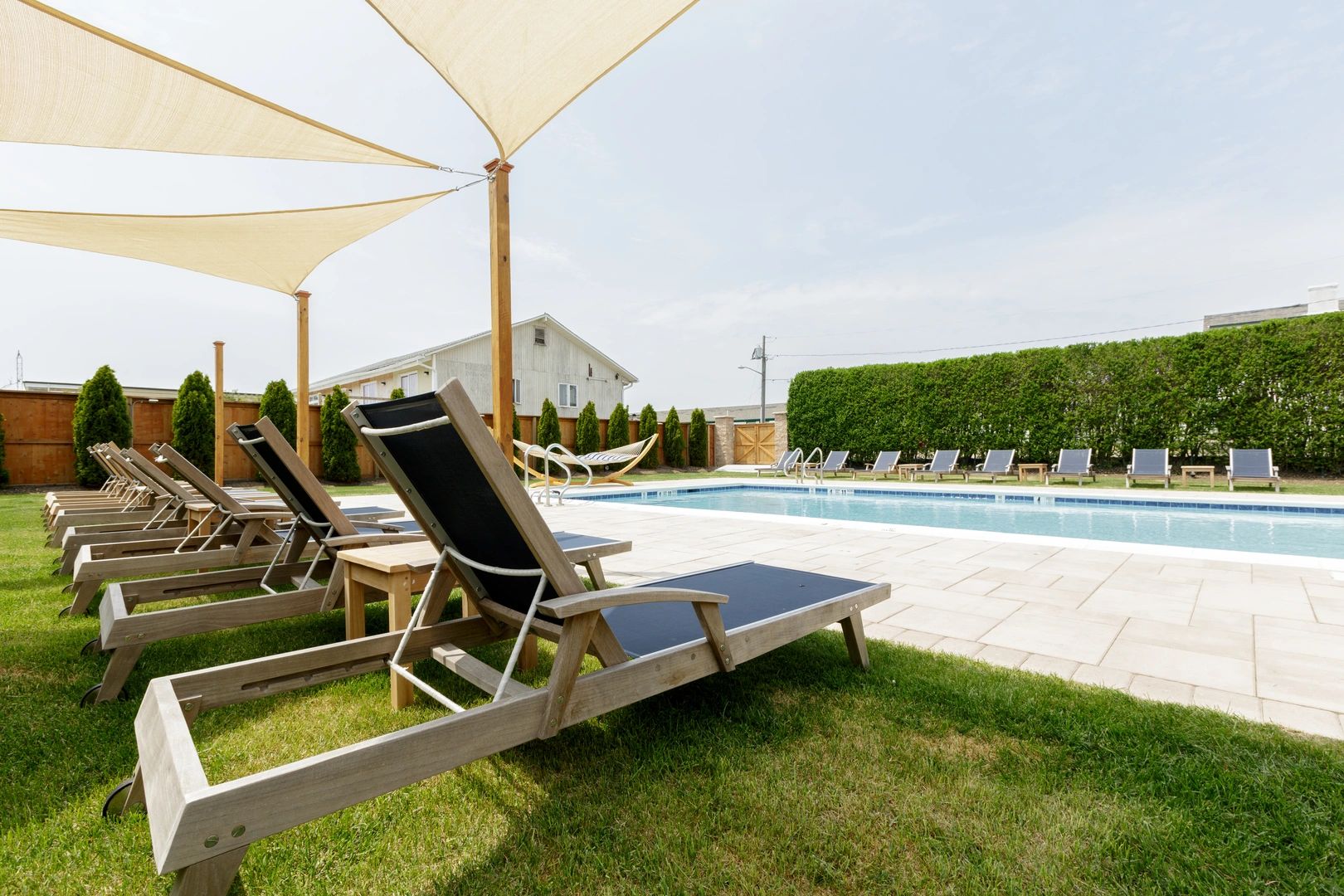 a pool area with lounge chairs and umbrellas