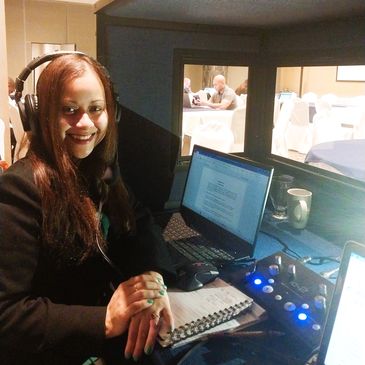 Persona en cabina de interpretación con la consola y auriculares.