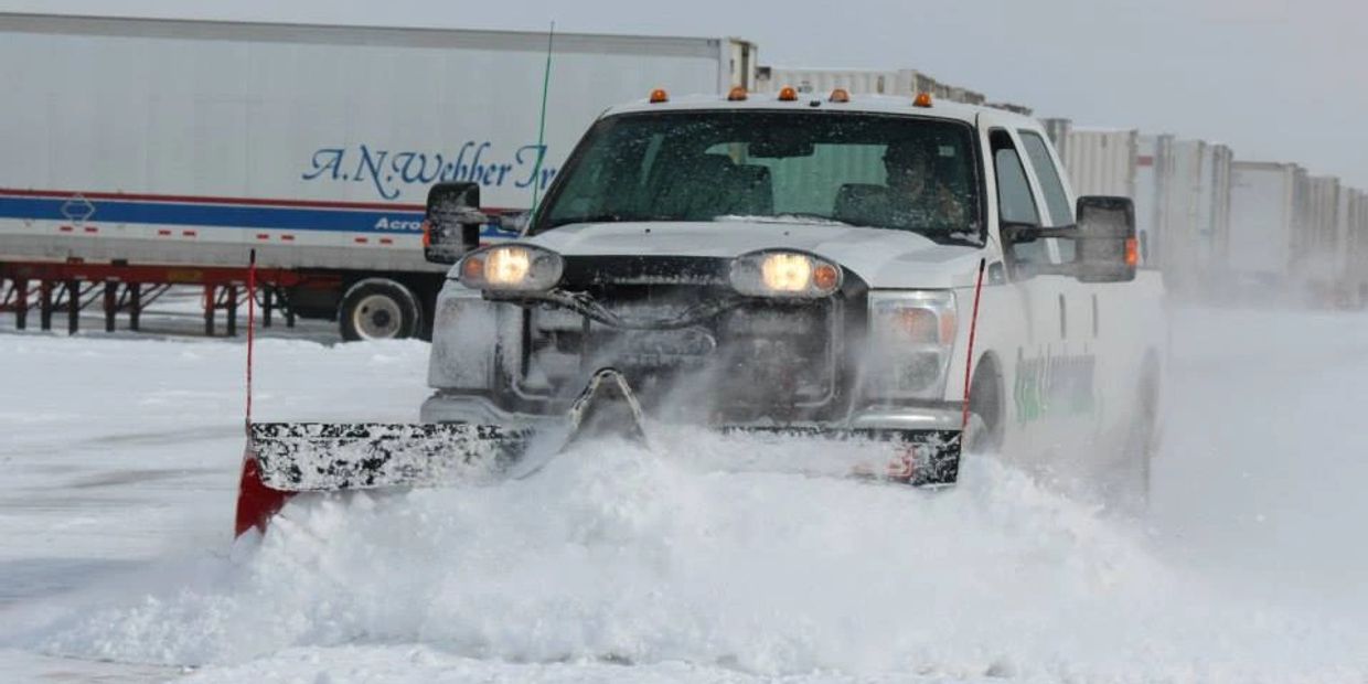Ryan's Landscaping truck plows snow at private airport hanger
