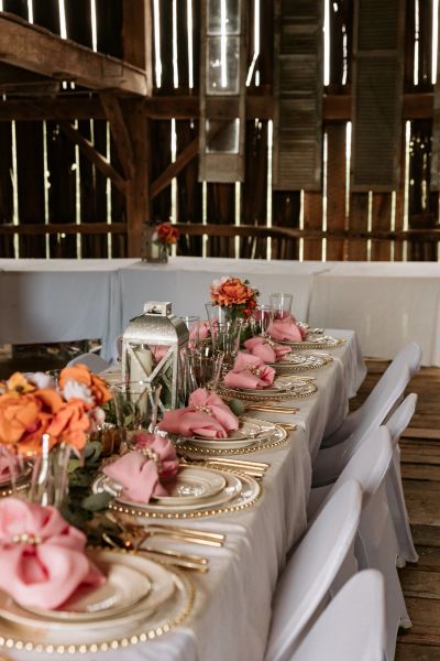 Elegant table setup with pink napkins and flowers.