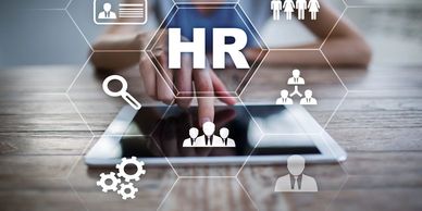 Person interacting with a tablet showing HR icons and concepts.