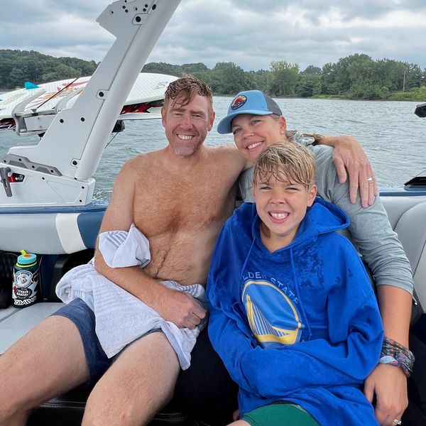 Family enjoying a boat ride with smiles and wet hair.