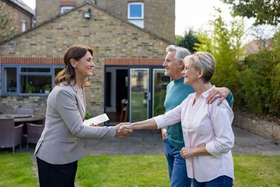 Agent greeting clients outside house