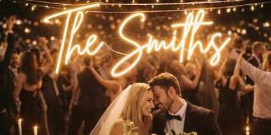 A joyful bride and groom celebrating with guests under warm lights.