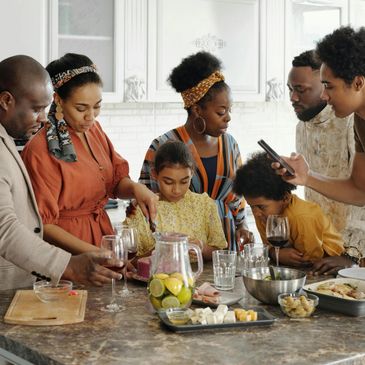 Family gathered in the kitchen preparing and enjoying a meal together.