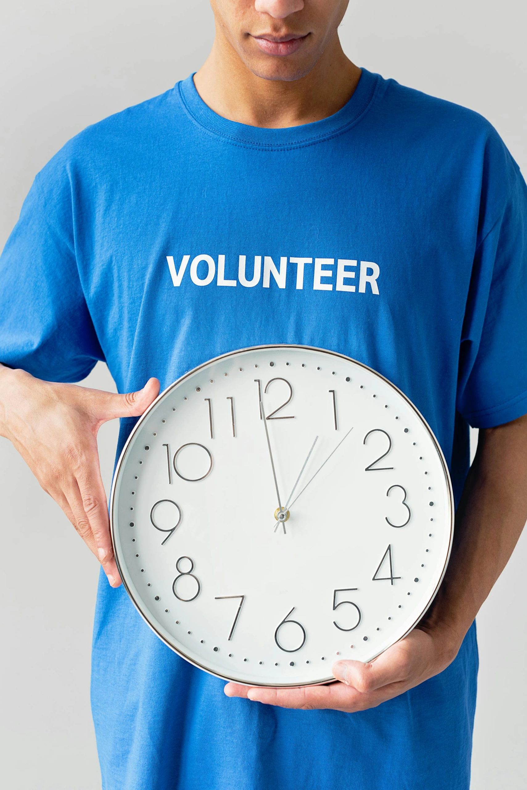 Volunteer holding a clock showing the importance of time.