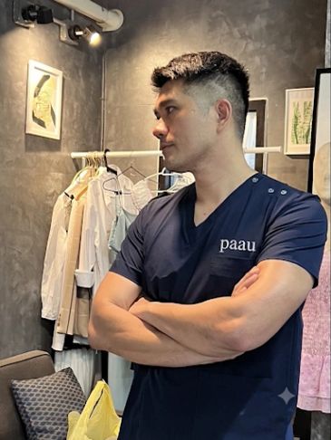 Man in navy blue shirt standing with arms crossed.