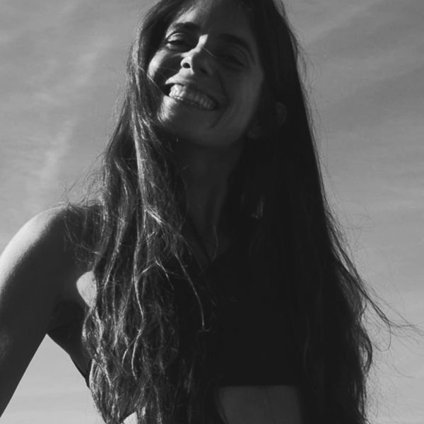 Mujer sonriente con cabello largo al viento.
