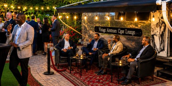 Men enjoying cigars and drinks in a vintage cigar lounge.