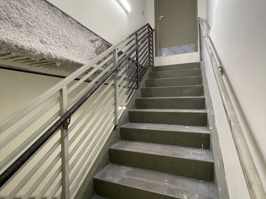Concrete staircase with metal railings in a building interior.