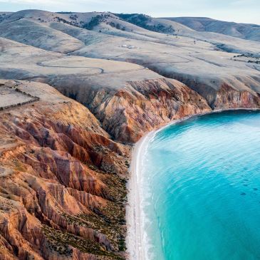 Colorful cliffs along a bright turquoise coastline.