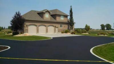 Modern house with a spacious triple garage and freshly paved driveway.