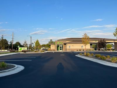 Empty parking lot in front of a modern building on a clear day.