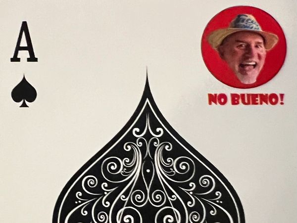 Ace of spades card with a humorous sticker showing a man's face and the text 'NO BUENO!'