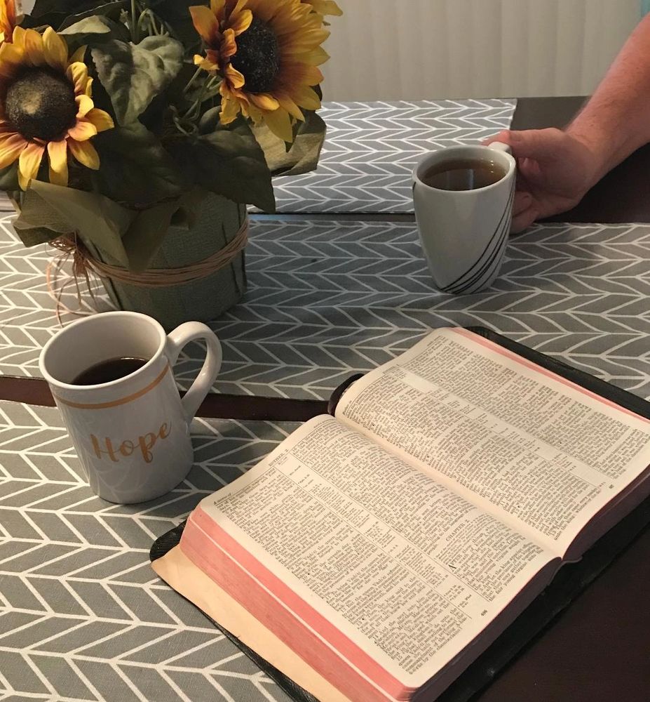 Cups of coffee on the table with an open Bible.