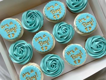 Blue cupcakes and cookies saying "It's a Boy!" for a baby shower.