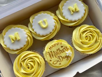 Yellow themed cupcakes spelling 'MUM' and 'Happy Mother's Day'.