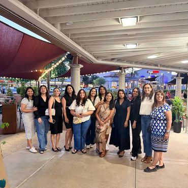 Group of women posing at an outdoor covered area.