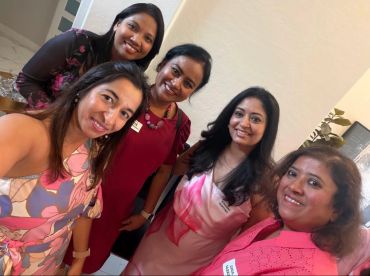 Group of five smiling women posing for a selfie.
