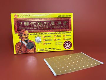 box of pain patches along side a singular unwrapped pain patch