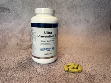 bottle of ultra preventative X vitamins with a small pile of the pills next to it 